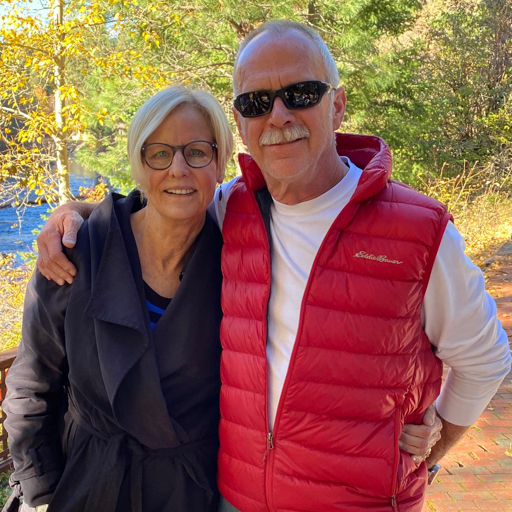 David and Carol Carrothers outside in front of trees